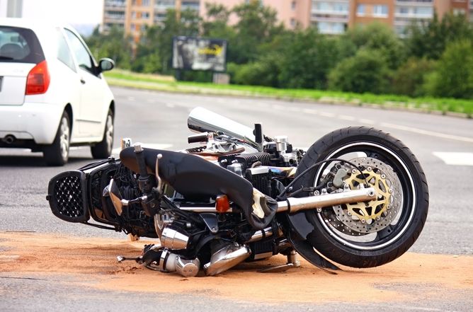 A motorcycle crushed on its side after an accident.