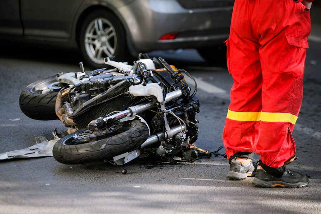 Crashed motorcycle after road accident with a car.
