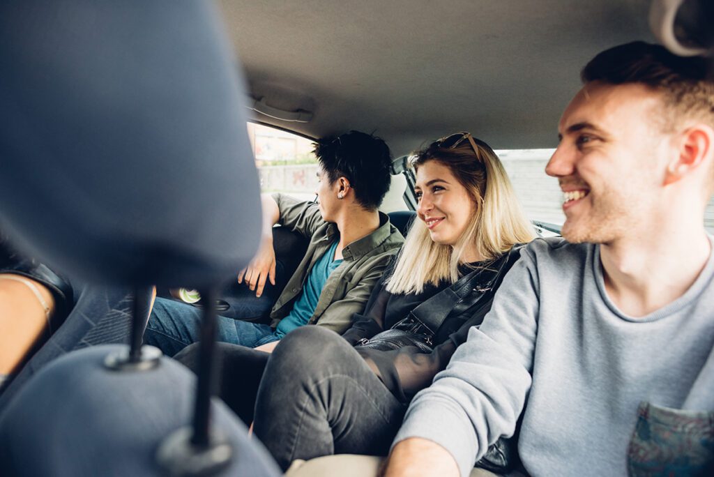 A group of friends riding together in the backseat of a rideshare.